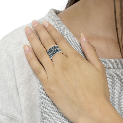 White metal ring with rows of prong-set blue and white round gemstones in a grid pattern, shown on a model's hand from a front angle.