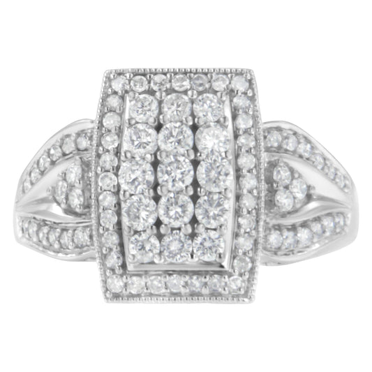 Top-down close-up of a white ring with a rectangular cluster of round white gemstones in a pave setting and additional gemstones on the band.