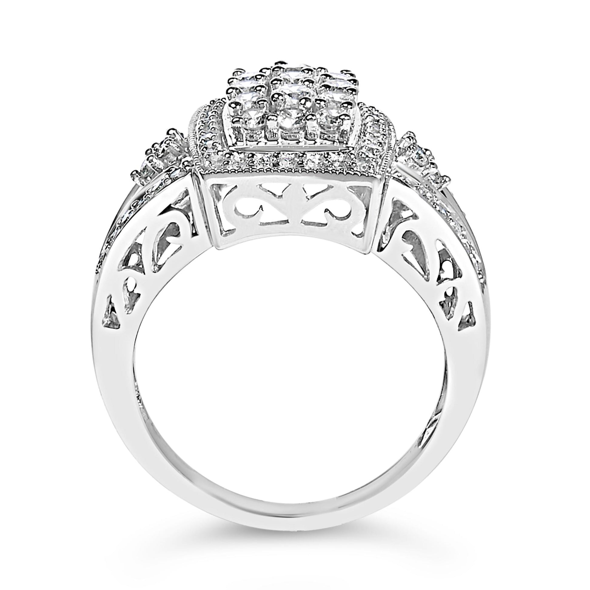 Close-up front angle view of a white metal ring with an intricate openwork band and a cluster of round white gemstones set in a pave style on top.