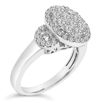 White metal ring with an oval cluster of round gemstones in prong settings on top and one side, alongside a small section of baguette gemstones in channel settings, shown from a slight angled top view.