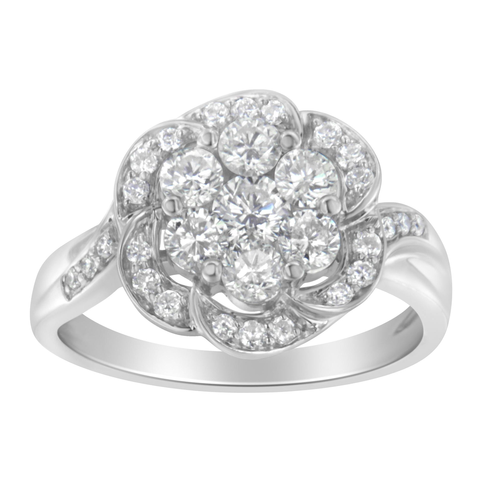 Front angle view of a white metal ring featuring a flower-shaped cluster of round white gemstones in prong settings, with additional smaller round white gemstones decorating the petals and band.