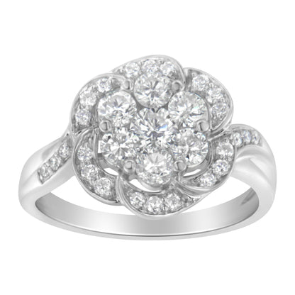 Front angle view of a white metal ring featuring a flower-shaped cluster of round white gemstones in prong settings, with additional smaller round white gemstones decorating the petals and band.