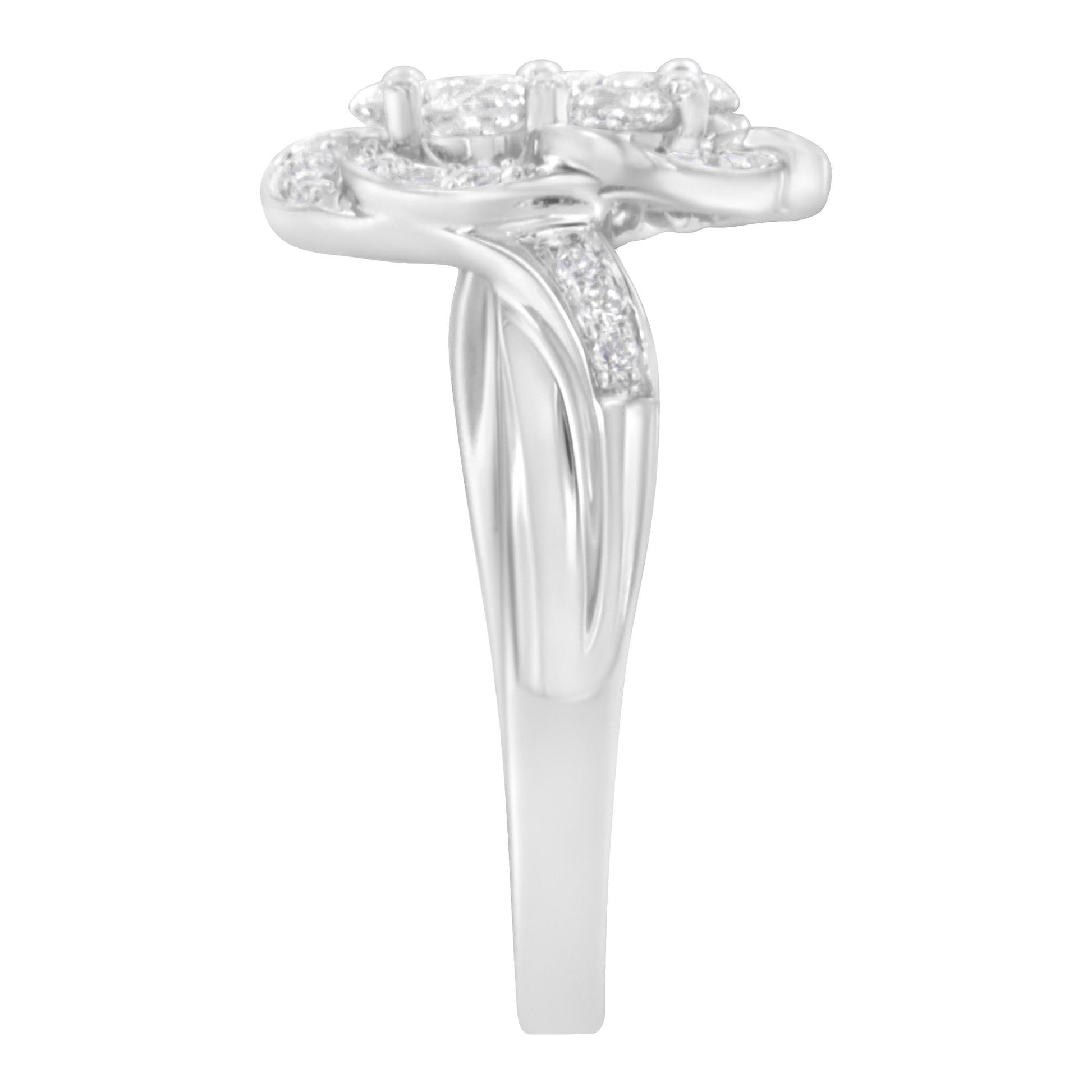 Side view of a white metal ring with a split band featuring multiple round white gemstones in prong settings on top and along the sides.