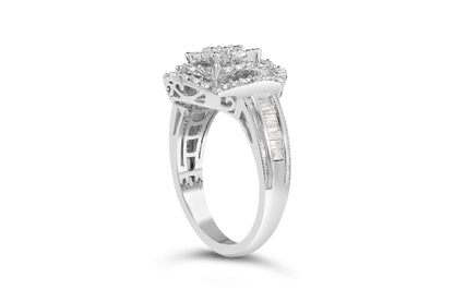 White metal ring with a cluster of round white gemstones in prong settings on top, accented by baguette white gemstones in channel settings along the band, shown from a side angle.