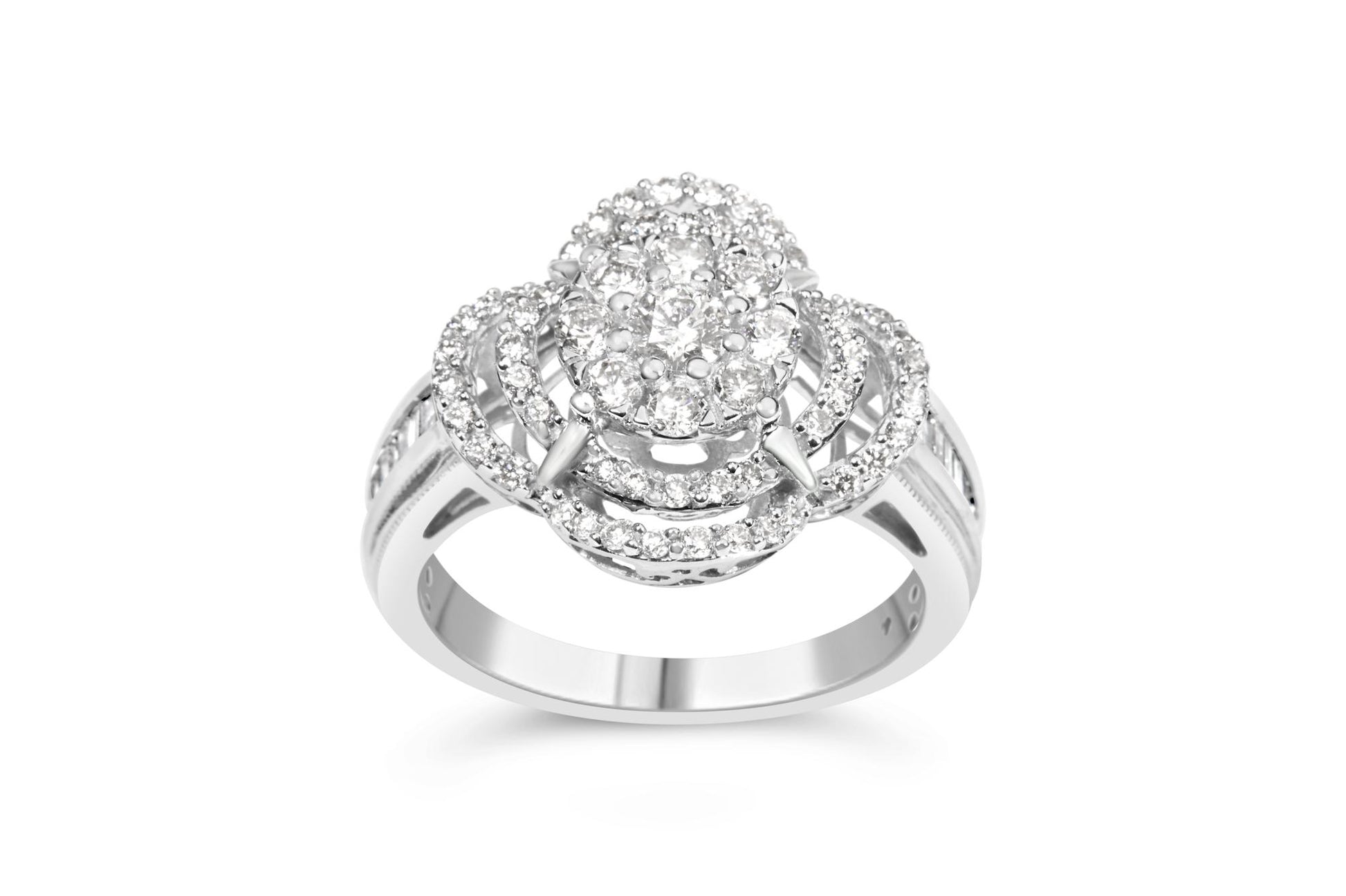 Front-facing close-up of a white metal ring featuring an oval cluster of round white gemstones in prong settings at the center, surrounded by three concentric oval loops also set with small round white gemstones. The band has channel-set baguette-shaped white gemstones and additional round white gemstones in prong settings along the sides. The ring is shown on a white background.