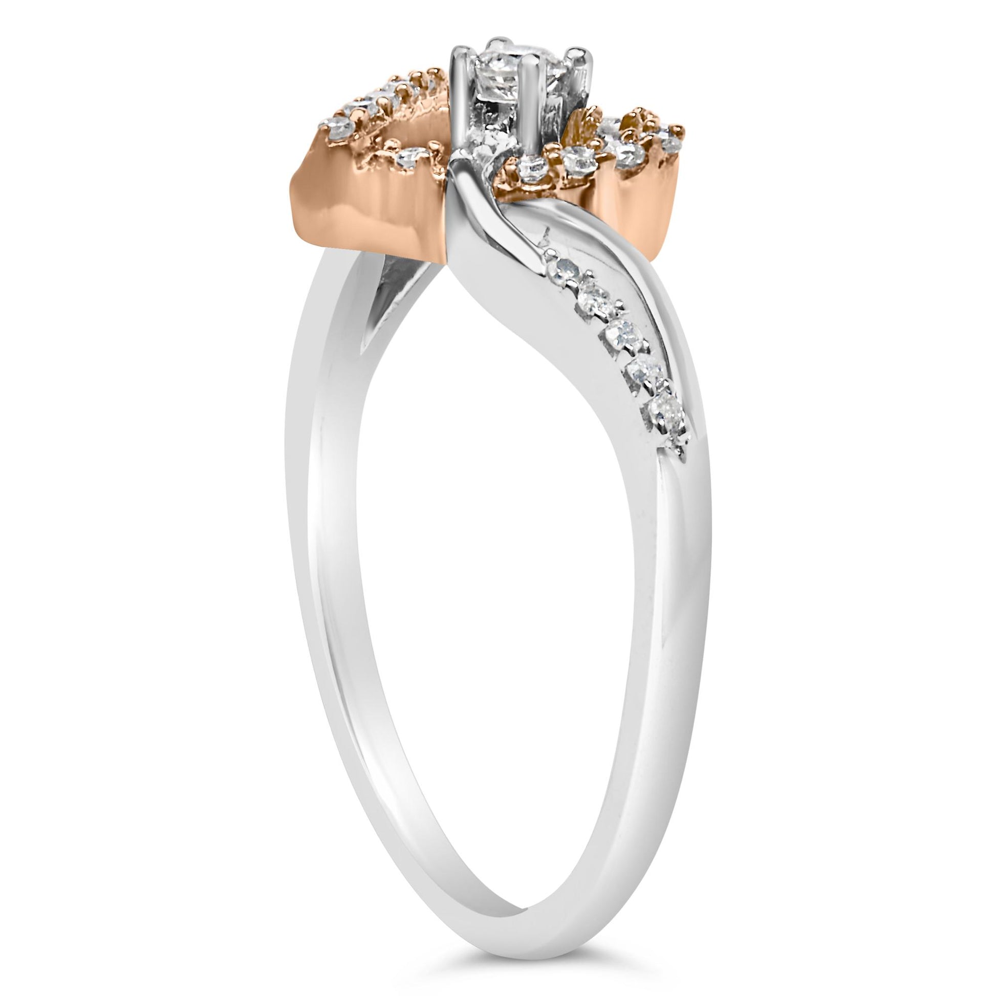 Side angle of a white and rose metal ring with round white gemstones in prong settings along the bands and a single raised round white gemstone at the center.
