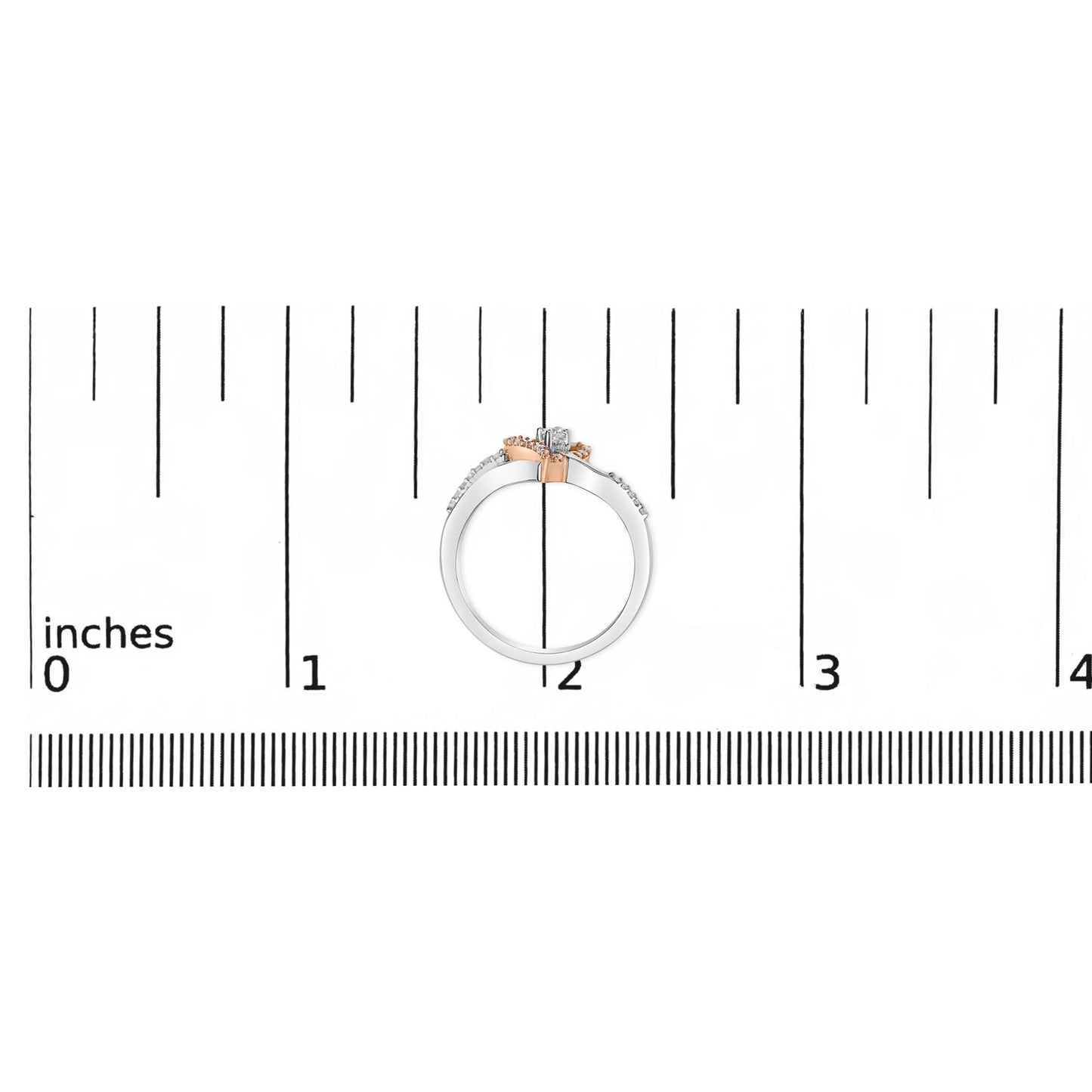 Top-down view of a white and rose metal ring with round prong-set white gemstones, placed on a ruler for size reference.