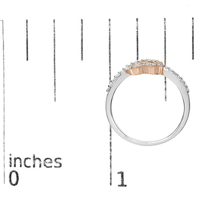 Side view of a rose-colored ring with round white gemstones in prong settings, placed on a ruler for size reference.