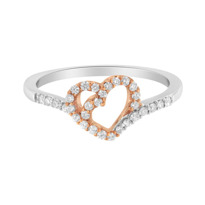 Close-up front angle of a white and rose metal ring featuring an open heart design with prong-set white round gemstones on the heart and along the white metal band.
