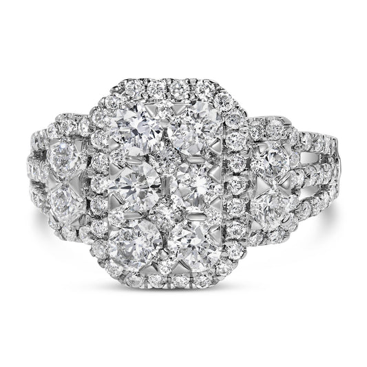 Front-facing shot of a white ring featuring multiple round white gemstones in prong settings arranged in a cluster and halo pattern with additional gemstones along the split band.