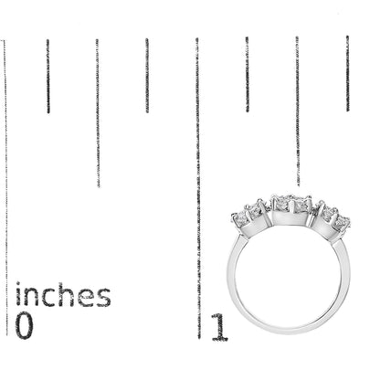 White metal ring with multiple round white gemstones in prong settings, shown from the side on a ruler for size reference.