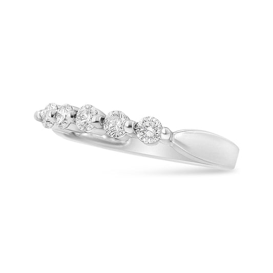 Side angle view of a white metal ring featuring a row of round white gemstones in pave setting.