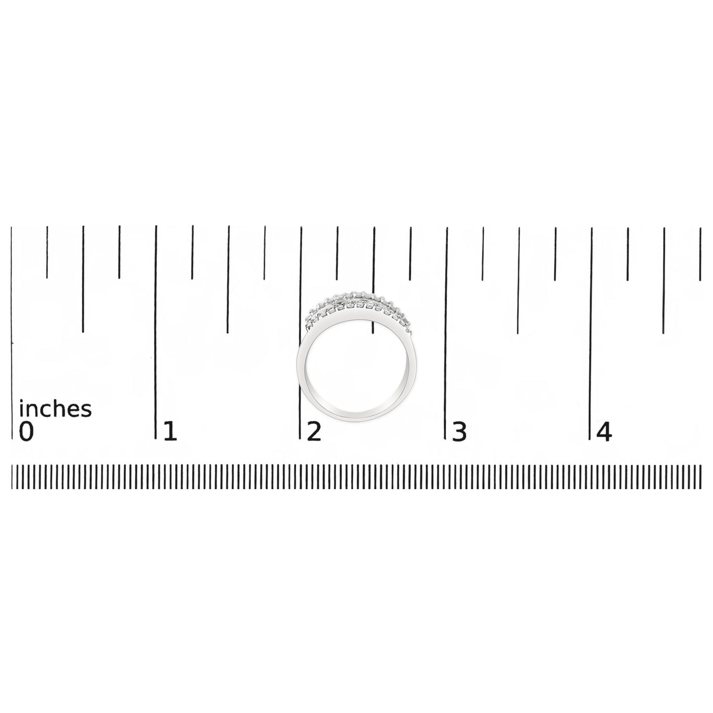 Top-down view of a white ring with round white gemstones in prong settings and baguette white gemstones in channel settings, placed on a ruler for size reference.