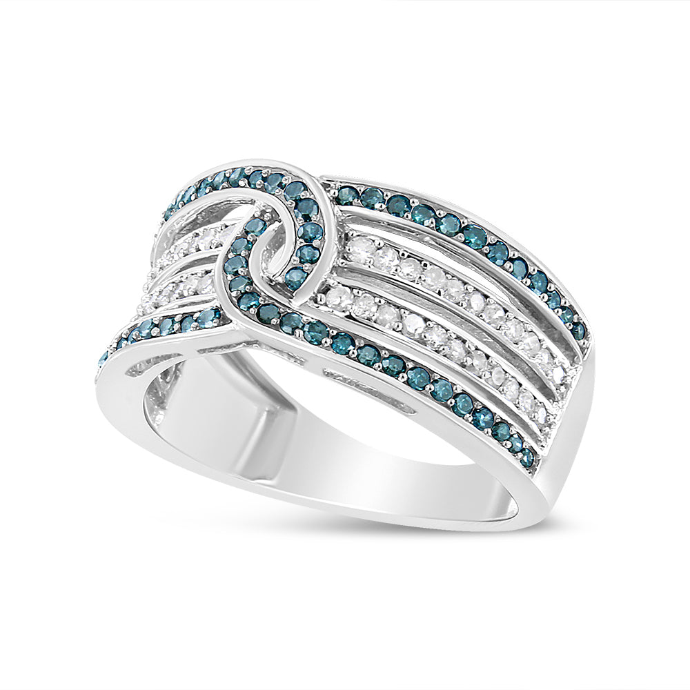 White metal ring shown in a close-up angled view, featuring intertwining bands set with round white and blue gemstones in a pave setting.