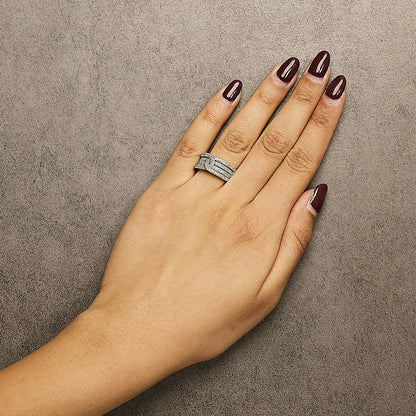 Top view of a hand wearing a white metal ring featuring multiple bands adorned with round white gemstones in shared prong settings.