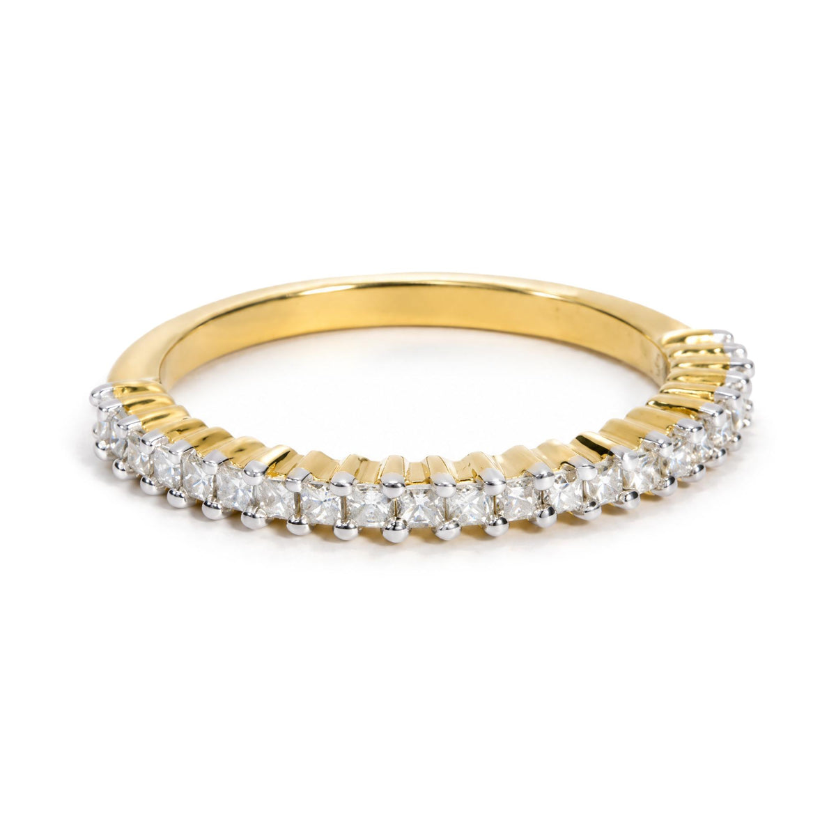 Close-up front angle of a yellow metal ring featuring a row of princess-shaped white gemstones in prong settings along the band, shown on a white background.