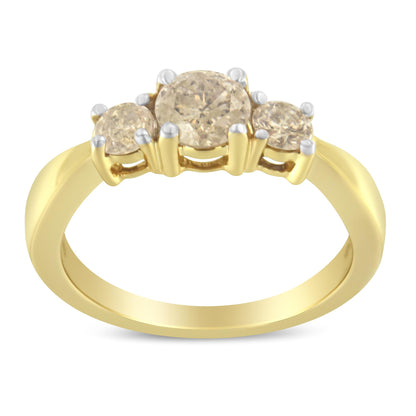 Front angle view of a yellow metal ring featuring one larger round white gemstone prong set between two smaller round white gemstones, also prong set.