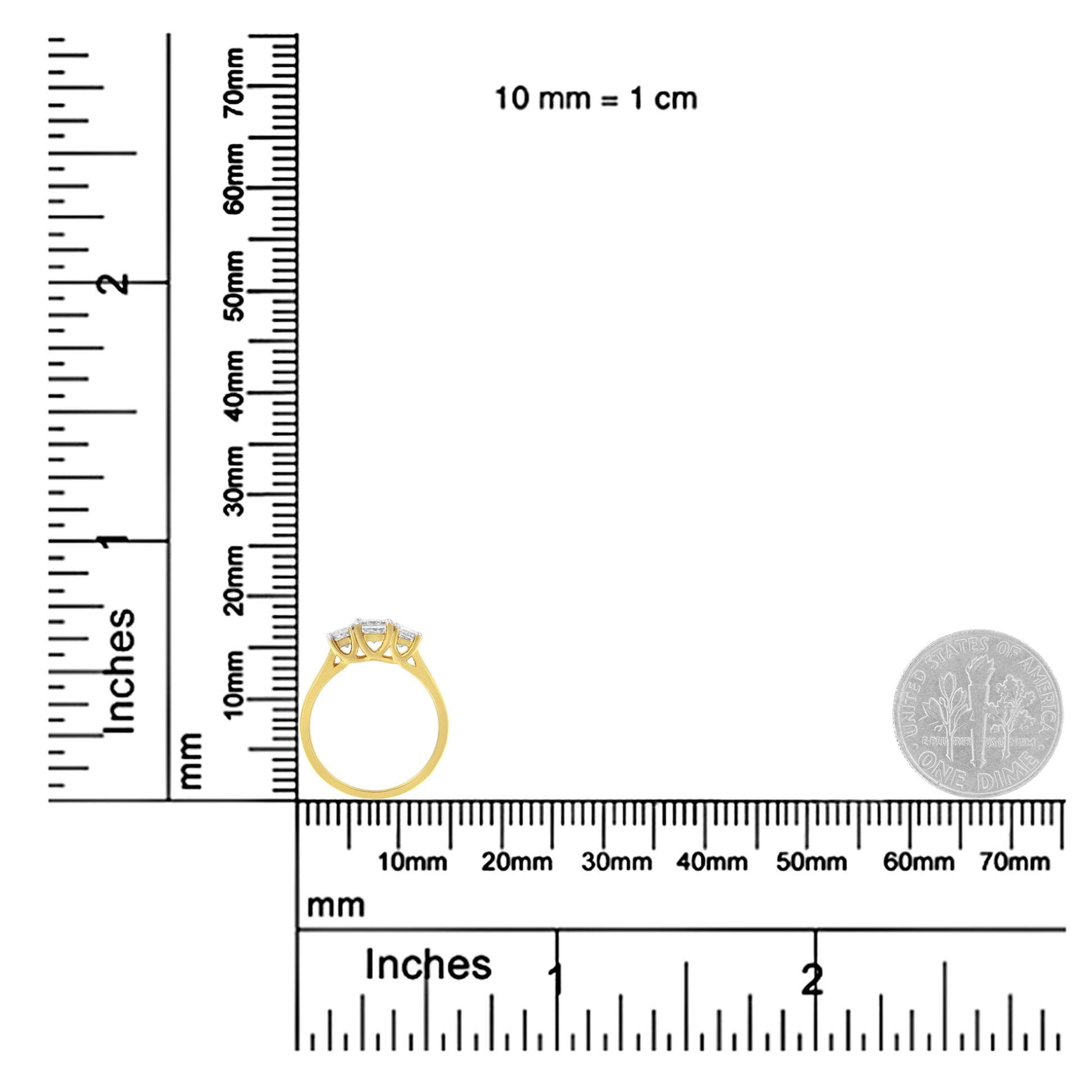 Yellow metal ring with three white princess-shaped gemstones in prong settings, side profile view, placed on a ruler and scale for size reference with a dime nearby.