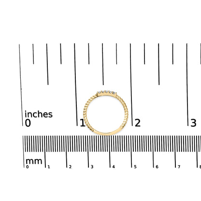 Yellow twisted band ring with five round white gemstones in prong setting, shown from the top on a ruler for size reference.
