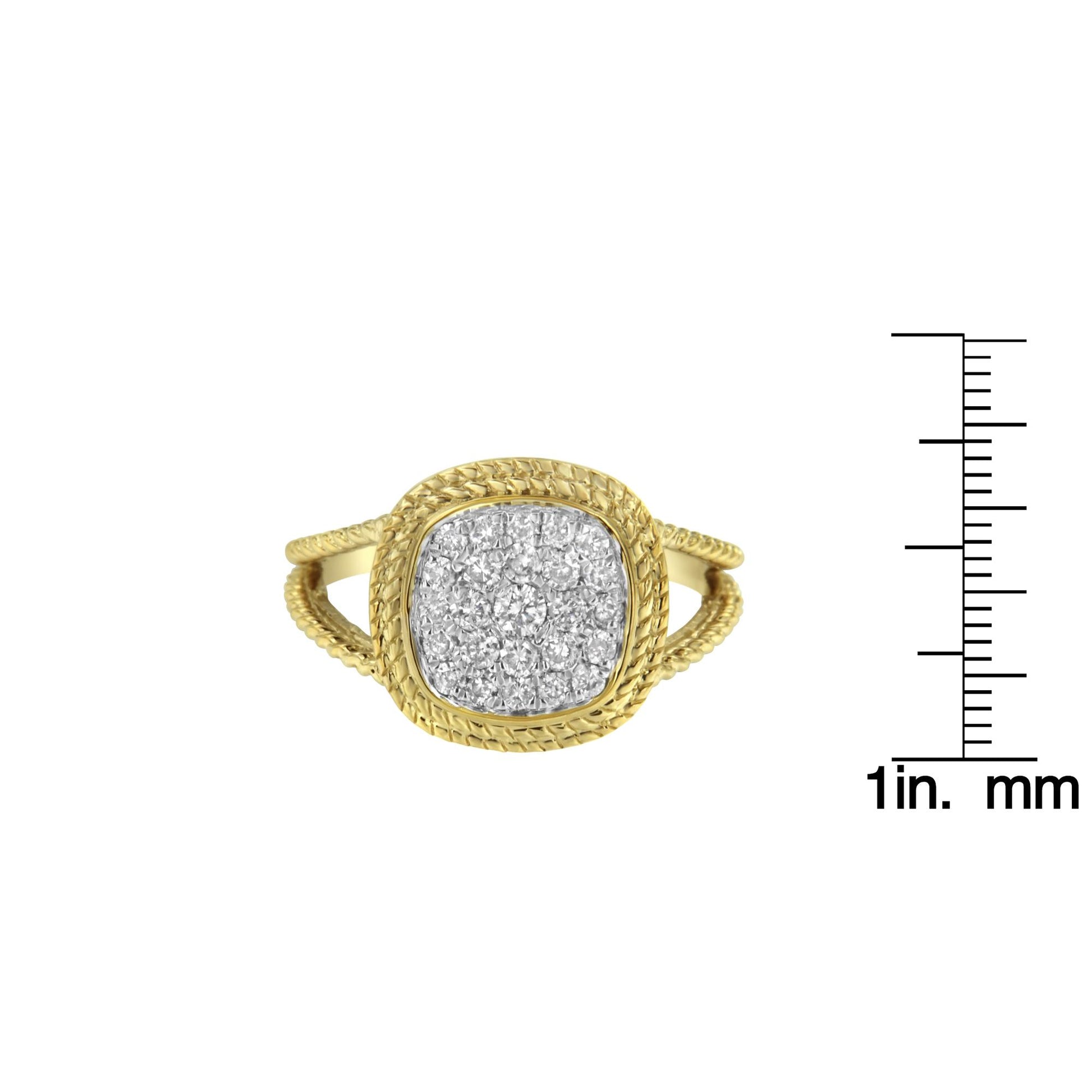 Front view of a yellow metal ring with a cushion-shaped cluster of round white gemstones in prong settings, shown next to a ruler for size reference.