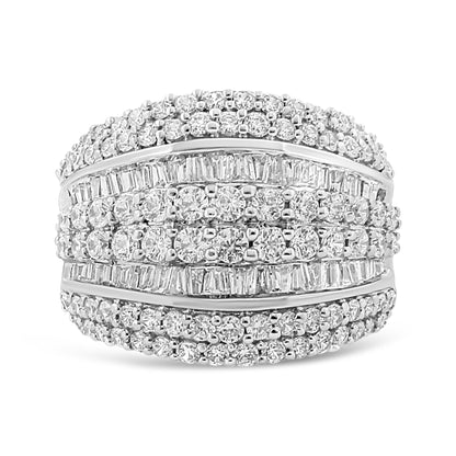 Front angle shot of a white metal ring featuring multiple rows of round white gemstones in prong settings and baguette white gemstones in channel settings across the band.