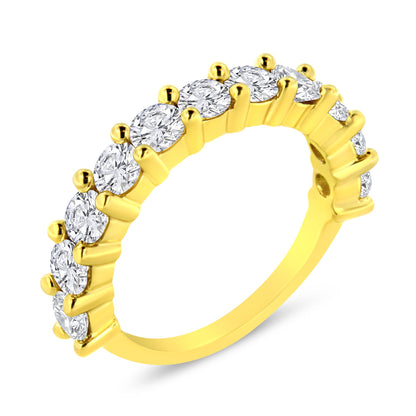 Yellow metal ring with round white gemstones in prong settings, shown at an angled close-up view.