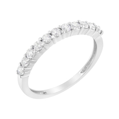 White metal ring with round white gemstones in prong settings along the top, shown from a side angle.