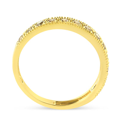 Close-up side view of a yellow metal ring with round white gemstones in a pave setting along the top half of the band.