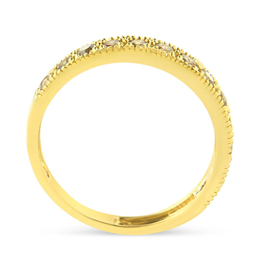 Close-up side view of a yellow metal ring with round white gemstones in a pave setting along the top half of the band.