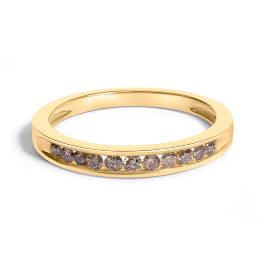 Close-up top front angle of a yellow ring with a channel setting of round white gemstones.