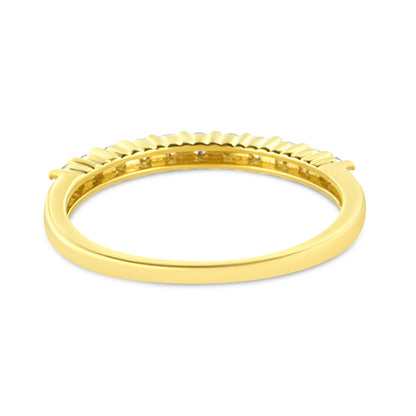 Close-up front angle of a yellow metal ring with multiple round white gemstones set in prong settings along the top band.