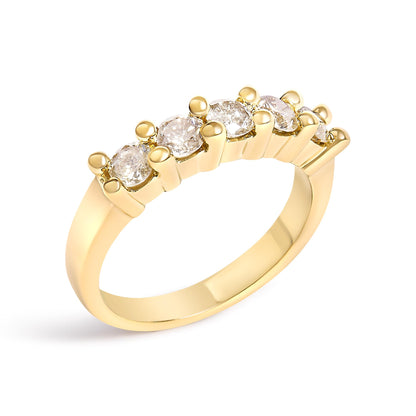 Yellow metal ring with five round white gemstones in prong settings, shown at a slight angle.