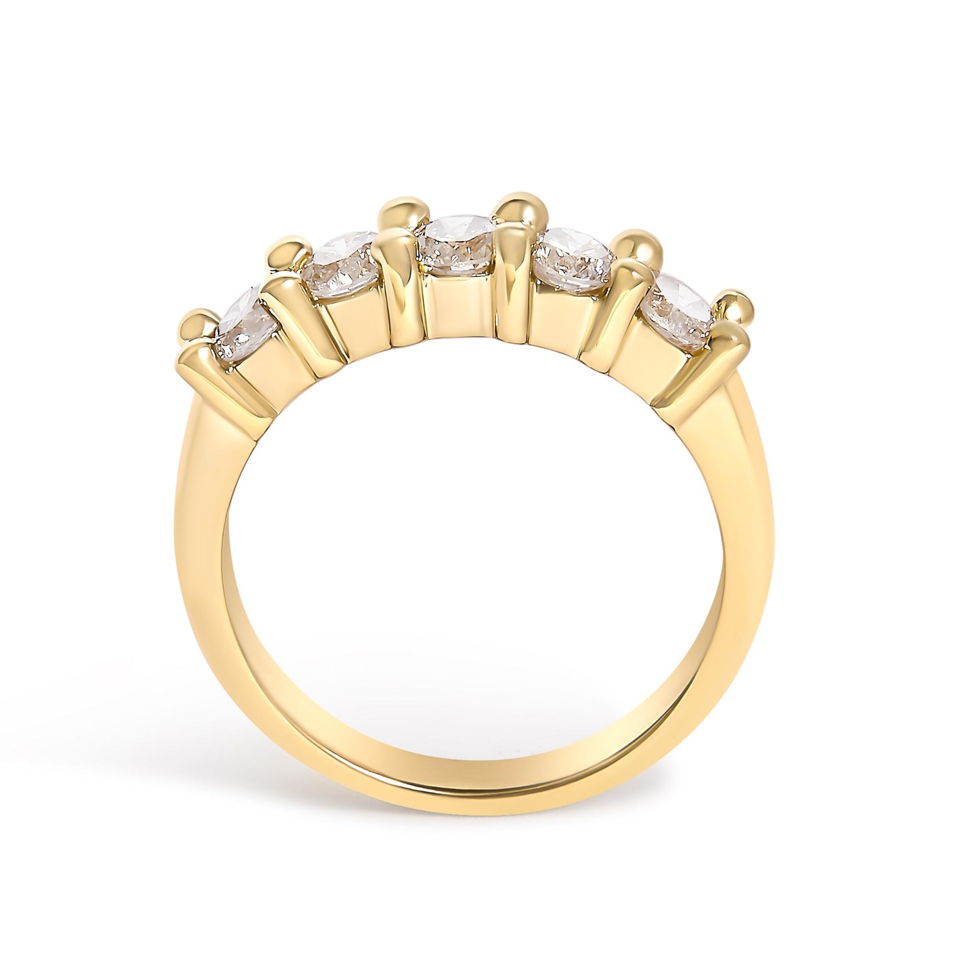 Yellow metal ring with five round white gemstones set in prongs on the top, shown from a side angle.