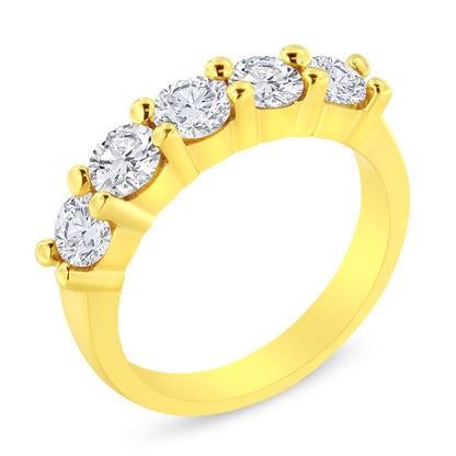 Yellow metal ring with five round brownish prong-set gemstones, shown in a close-up angled view.