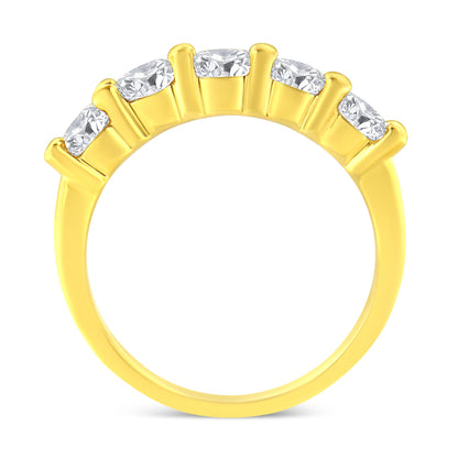 Yellow metal ring with five round prong-set white gemstones, shown from a side angle.