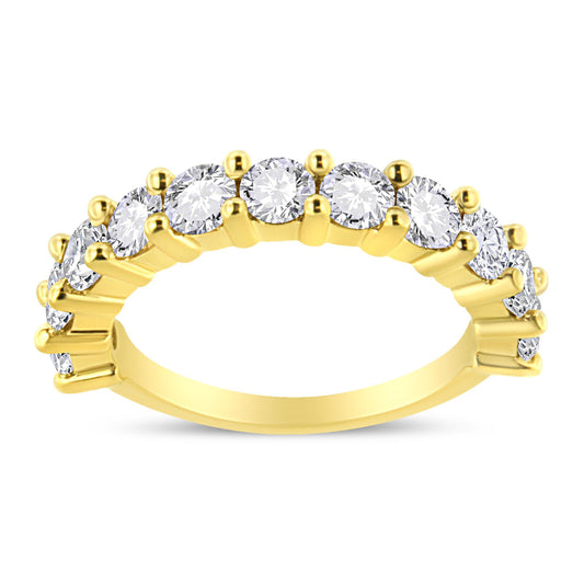 Yellow metal ring with round white gemstones in prong setting, shown from side angle.