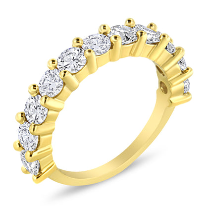 Yellow metal ring with round white gemstones in prong settings around the band, shown at an angled close-up.