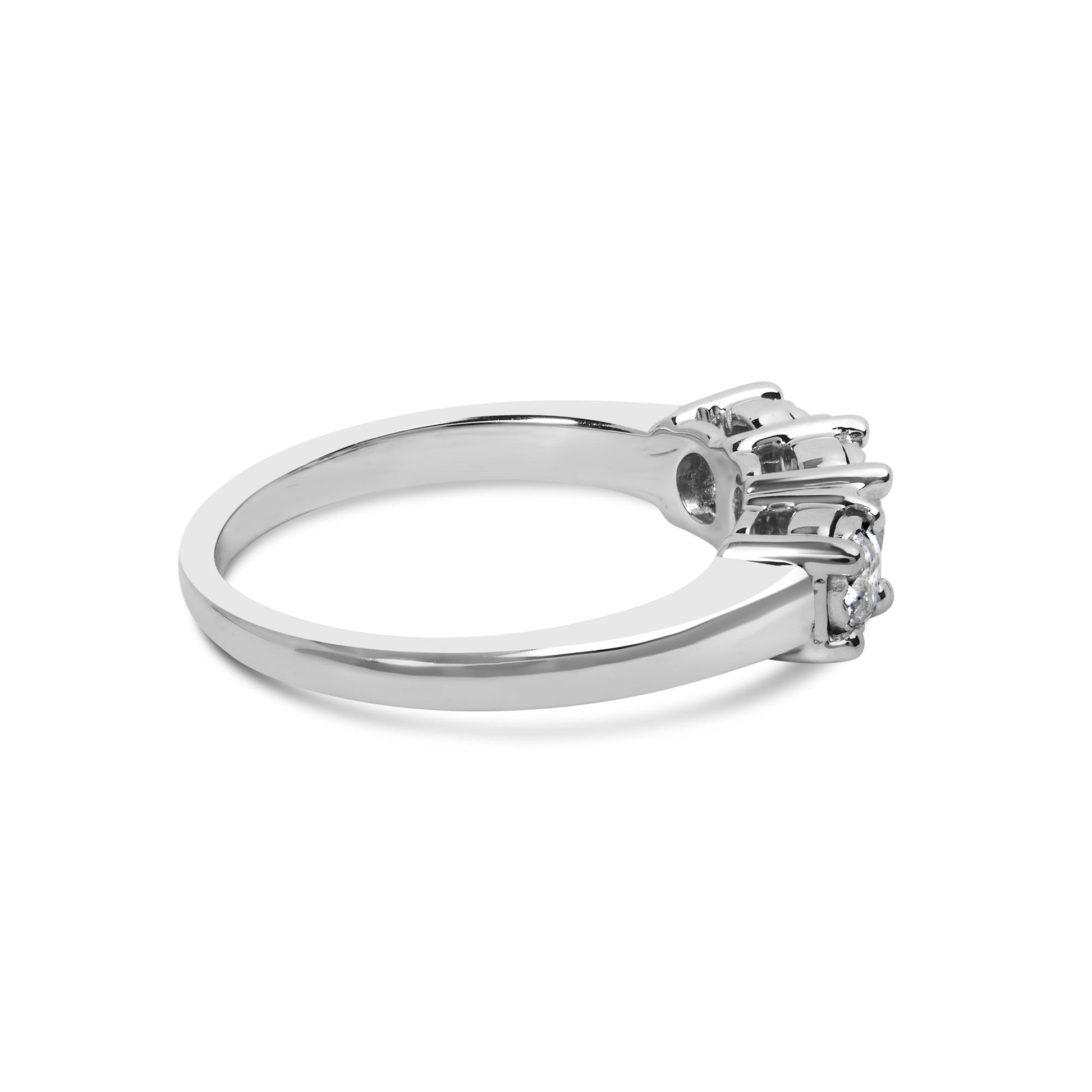 Side angled view of a white metal ring with three round white gemstones set in a miracle setting.