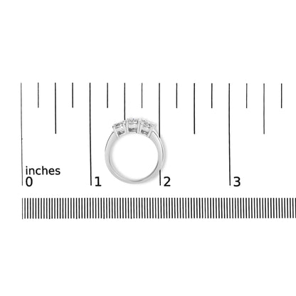 Top view of a white metal ring with three round white gemstones in miracle settings, placed on a ruler for size reference.