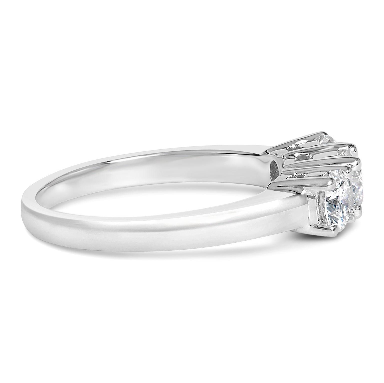 Side view of a white metal ring with three round white gemstones in a 4-prong setting.