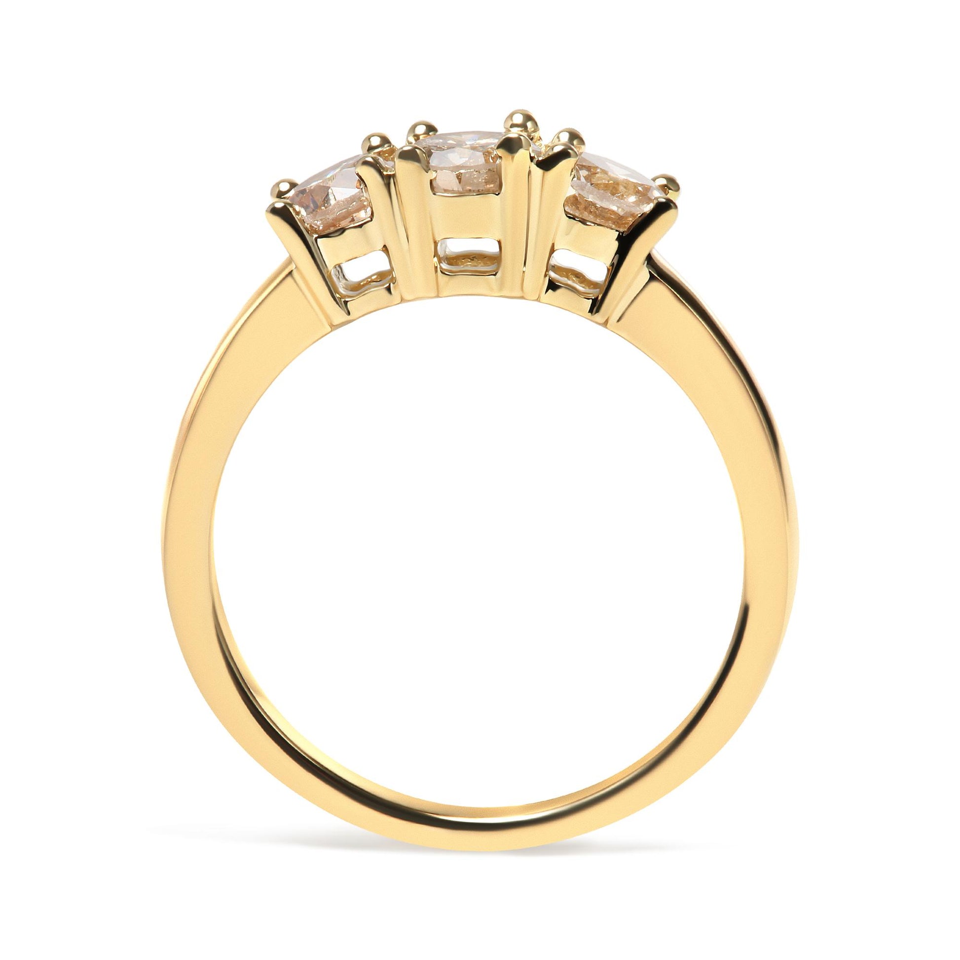 Yellow metal ring with three round white gemstones in prong settings, shown from the side angle.