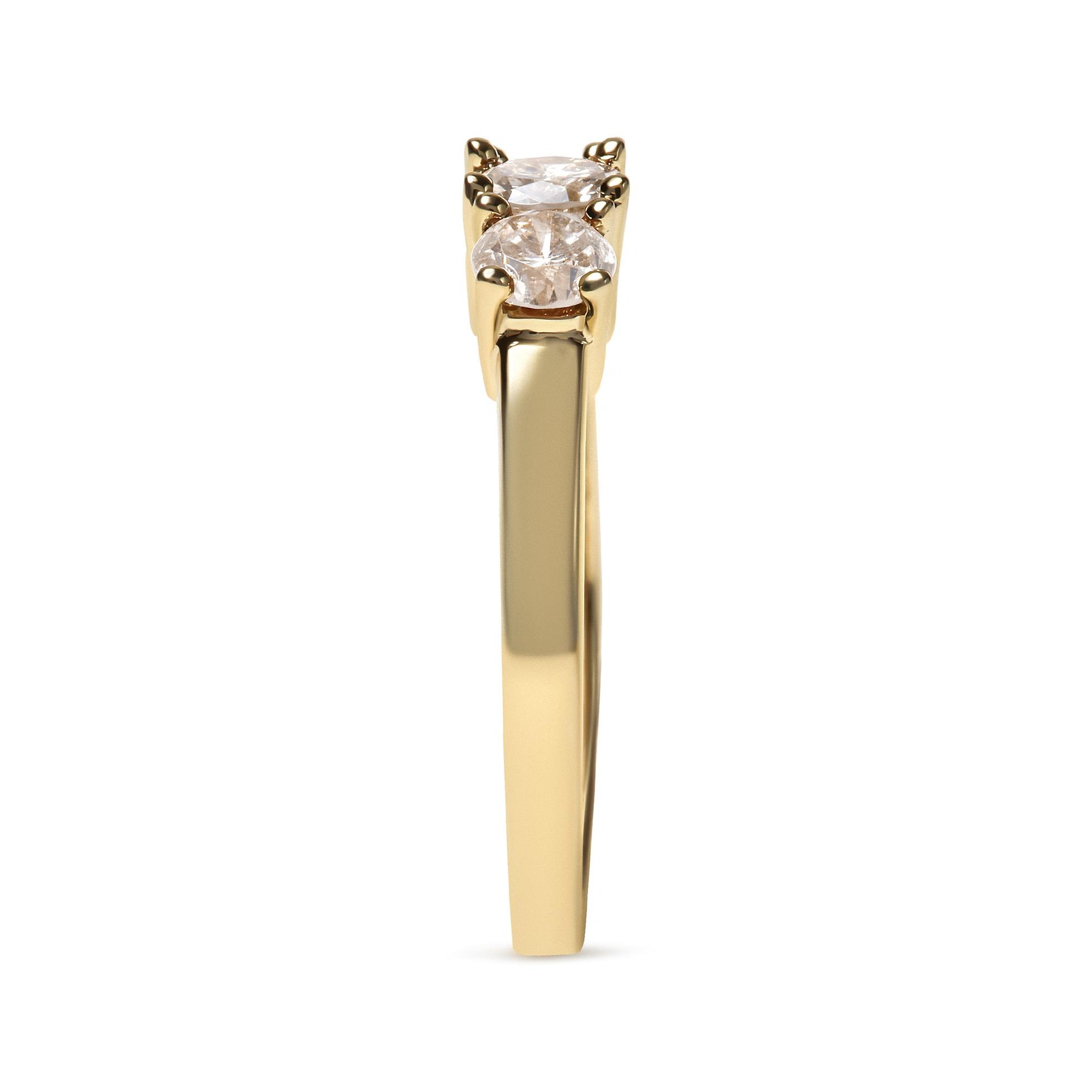 Side view of a yellow metal ring with three round white gemstones in prong settings.