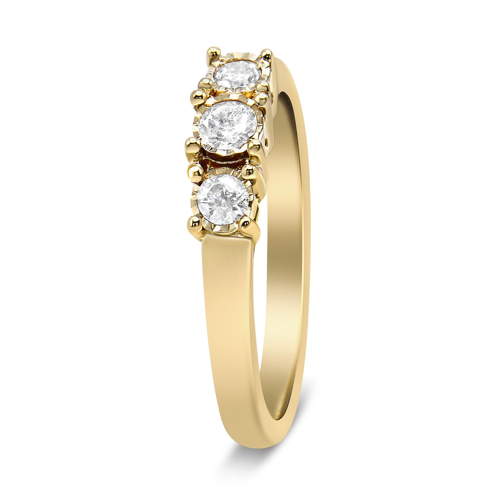 Yellow metal ring with three round white gemstones in miracle settings, shown at a slight side angle.