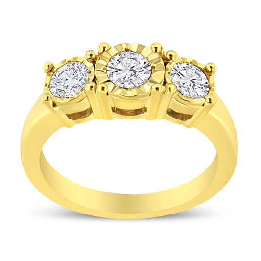 Yellow metal ring with three round white gemstones in miracle settings, front view.