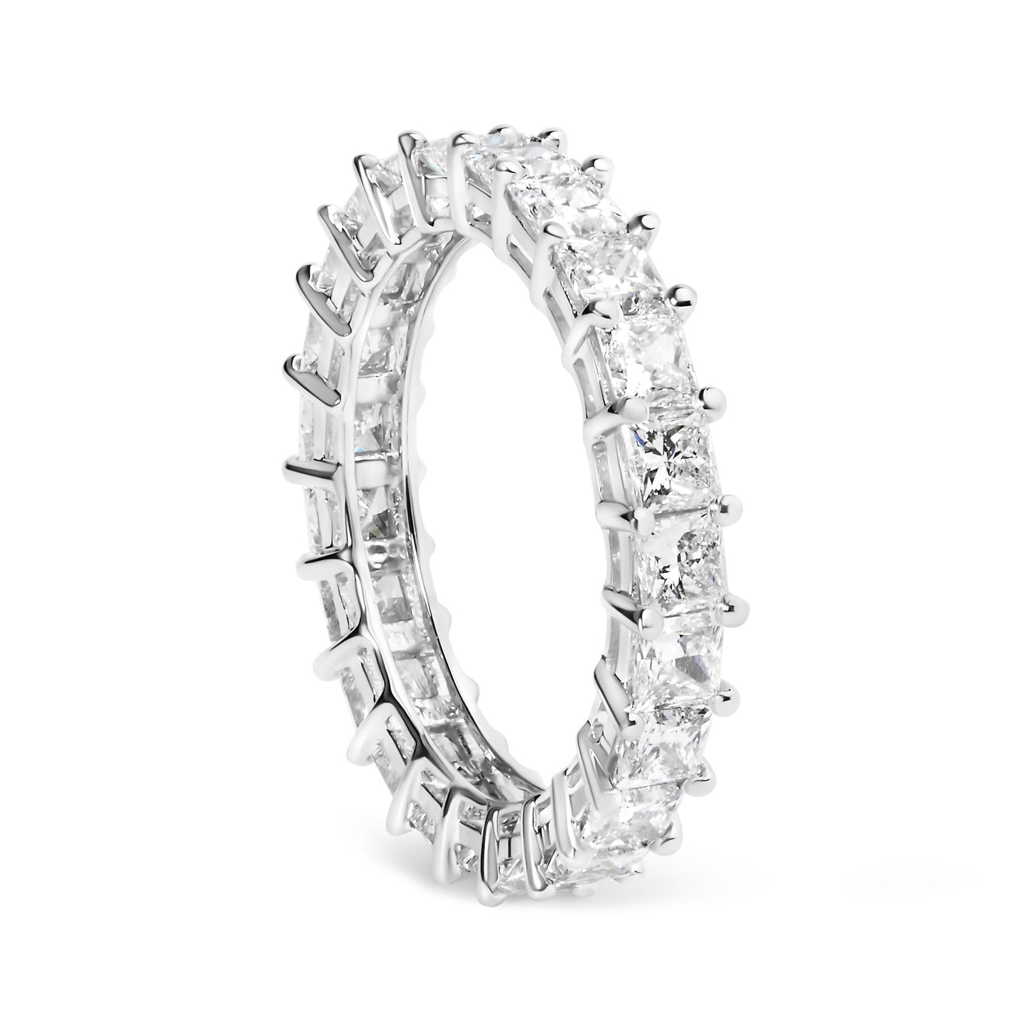 White metal ring with princess shape white gemstones in shared prong setting, shown at a slight angle.