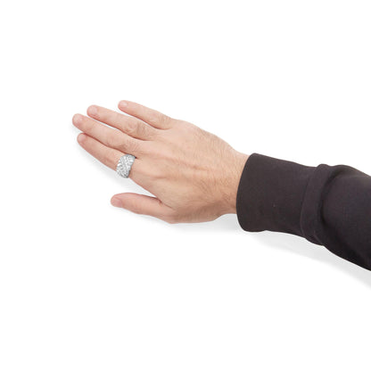 White metal ring with round white gemstones in channel setting, shown worn on a model's hand, side angle.