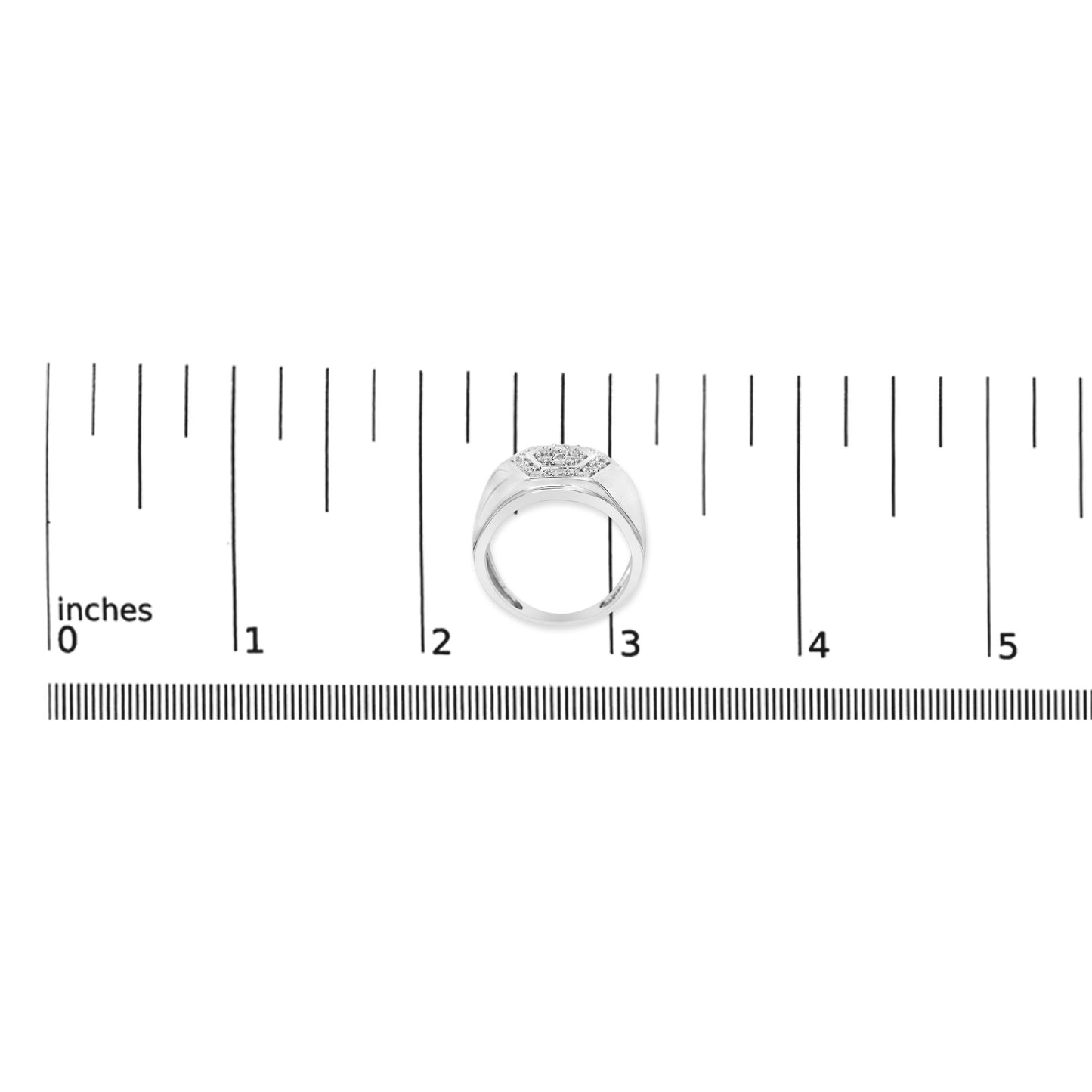 White metal ring with a cluster of round white gemstones set on top, shown from a top-down angle, placed on a ruler for size reference.