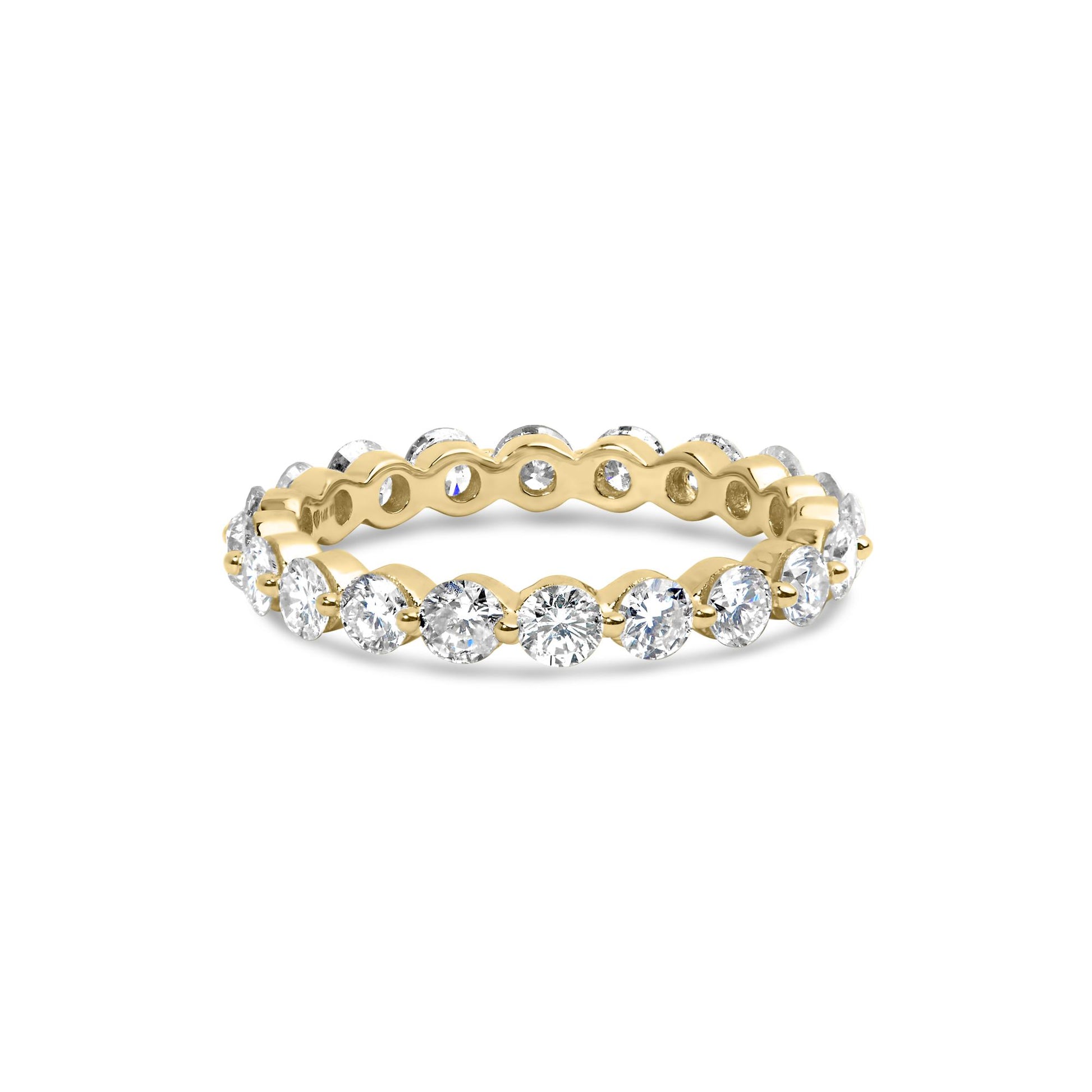 Yellow metal ring with round white gemstones in prong settings around the band, shown from a slightly elevated front angle.