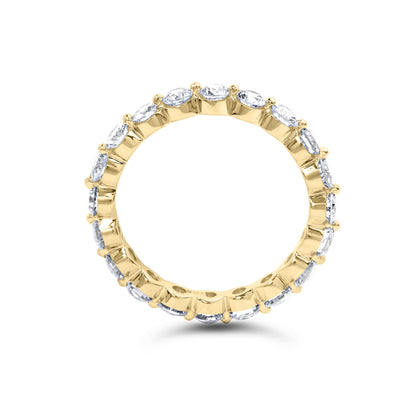 Yellow metal ring with round white gemstones in prong settings encircling the band, shown from a front angle.