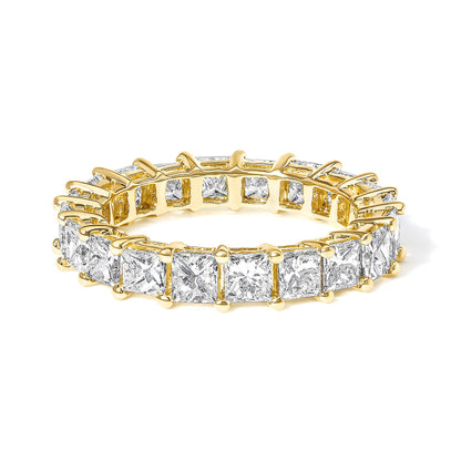 Yellow metal ring with princess-shaped white gemstones in prong settings, shown in a close-up angled side view.